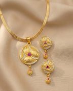 Gold necklace with matching earrings on a beige background