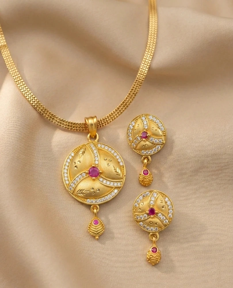 Gold necklace with matching earrings on a beige background