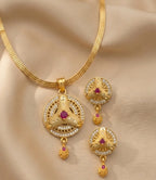Gold necklace with matching earrings on a beige fabric background