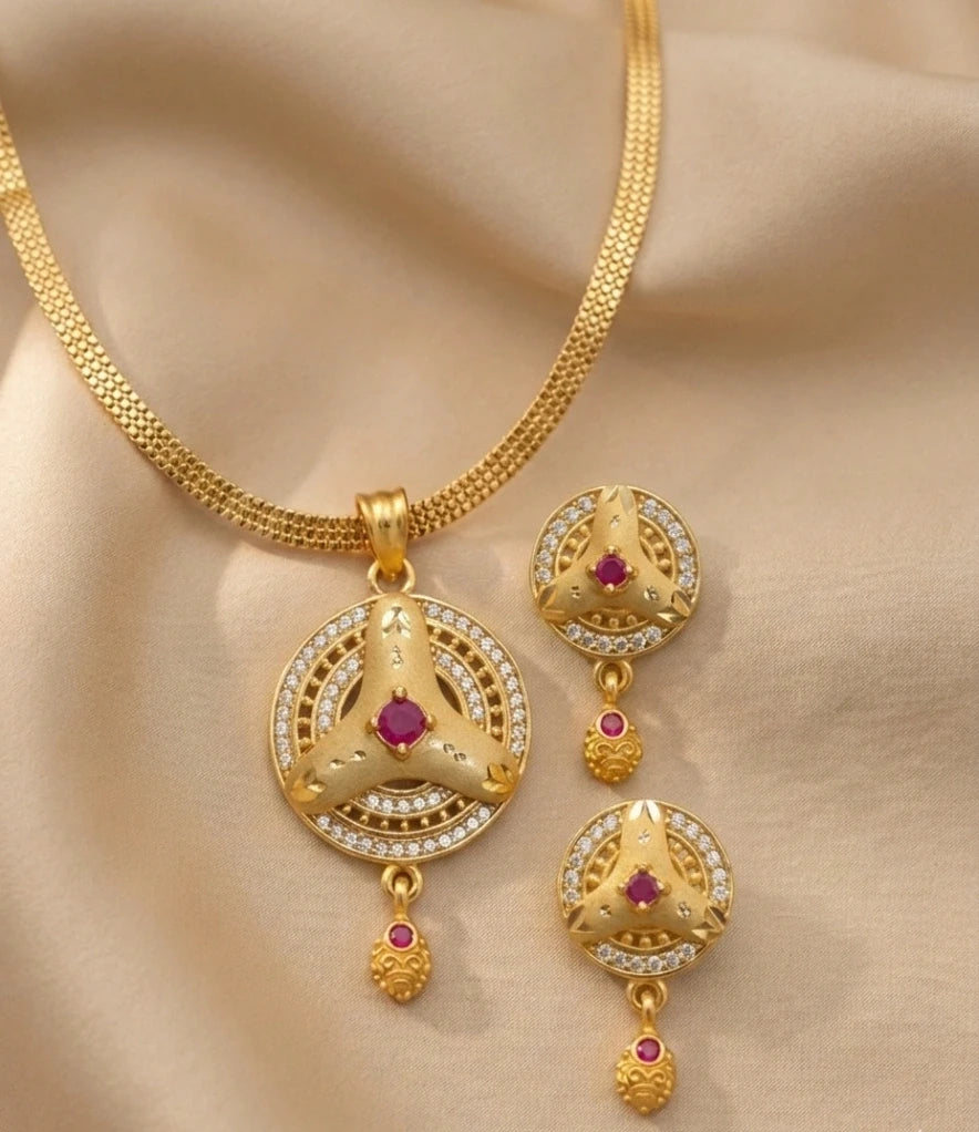Gold necklace with matching earrings on a beige fabric background