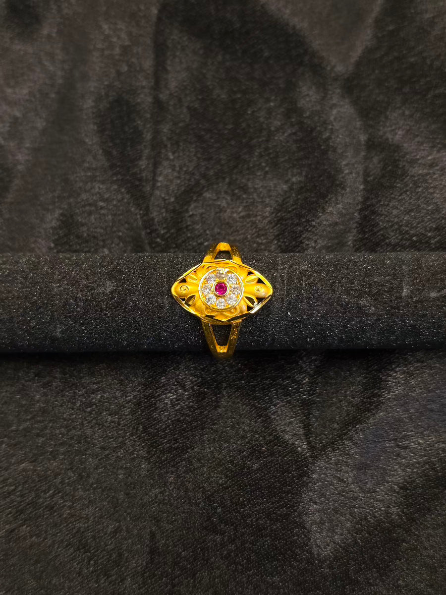 Gold ring with a central gemstone on a black velvet background