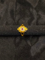 Gold ring with a central gemstone on a black velvet background