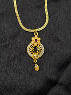 Gold necklace with a decorative pendant on a black background