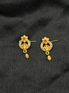 Pair of gold earrings with gemstones on a black background