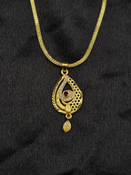 Gold necklace with a pendant on a black fabric background