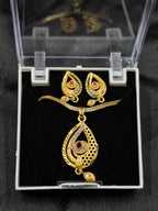Gold necklace and earrings set in a clear display case on a black background