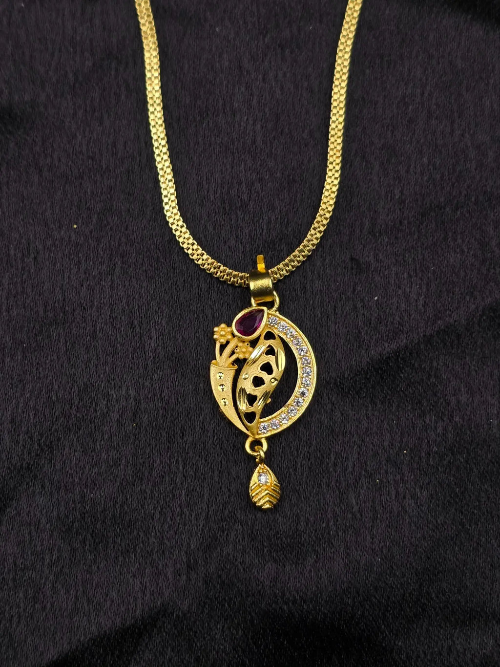 Gold necklace with a decorative pendant on a black background