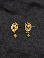 Pair of gold earrings with gemstones on a black fabric background
