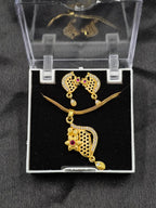 Gold necklace and earrings set in a clear display case on a black background
