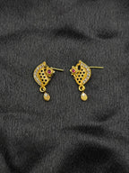 Gold earrings with gemstones on a black fabric background