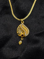 Gold necklace with a detailed pendant on a black fabric background