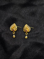 Gold earrings with gemstones on a black fabric background