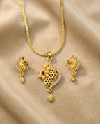 Gold necklace with matching earrings on a beige fabric background