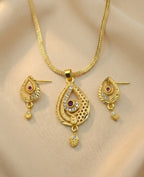 Gold necklace and earrings set on a beige background
