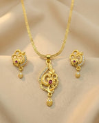 Gold necklace set with pendant and earrings on a beige background