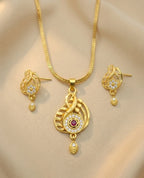 Gold necklace and earrings set on a beige background