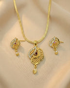 Gold necklace and earrings set on a beige background