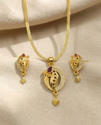 Gold necklace and earrings set on a beige fabric background