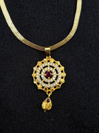 Gold necklace with a decorative pendant on a black background