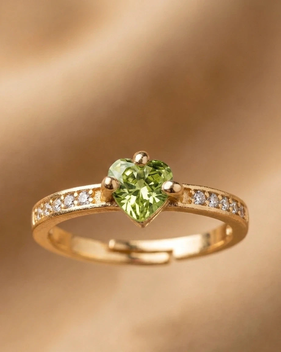 Gold ring with a green gemstone on a gold background