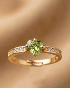 Gold ring with a green gemstone on a gold background