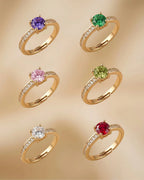 Set of gold rings with colorful gemstones on a beige background