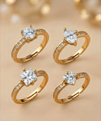 Four gold rings with diamond stones on a beige background