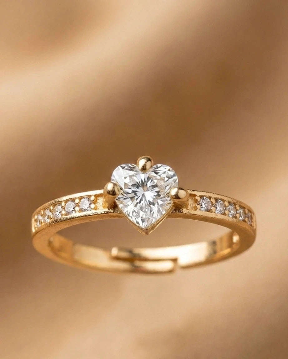 Gold ring with a heart-shaped diamond on a gold background